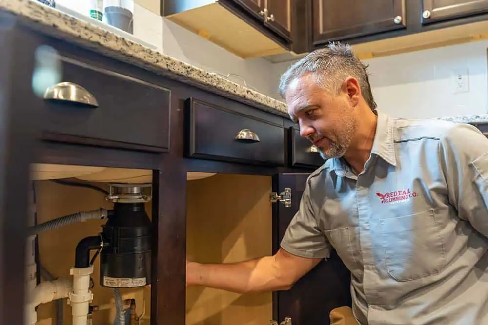 Man checking under the sink