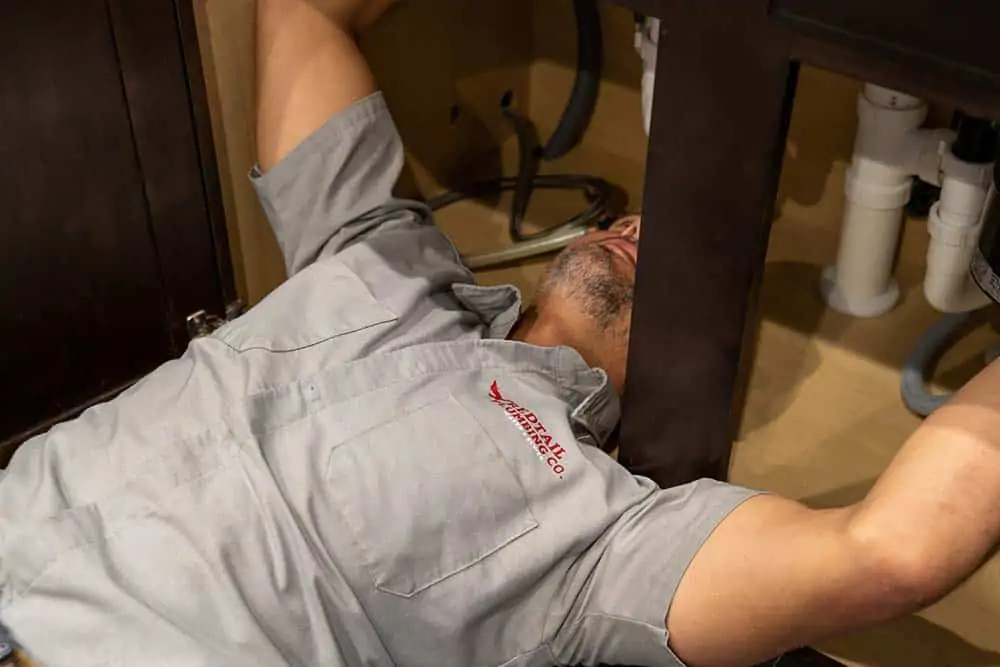 Man fixing underneath the sink