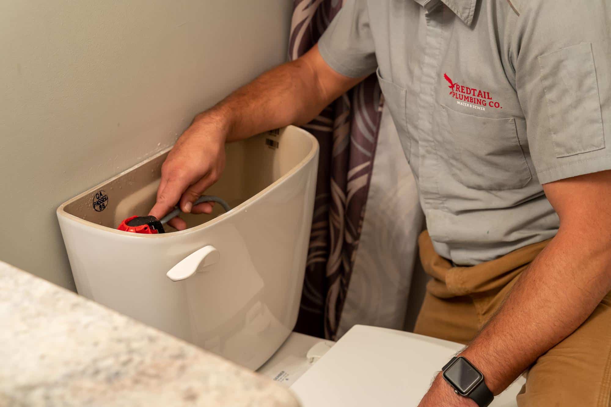 Redtail Plumbing fixing a toilet