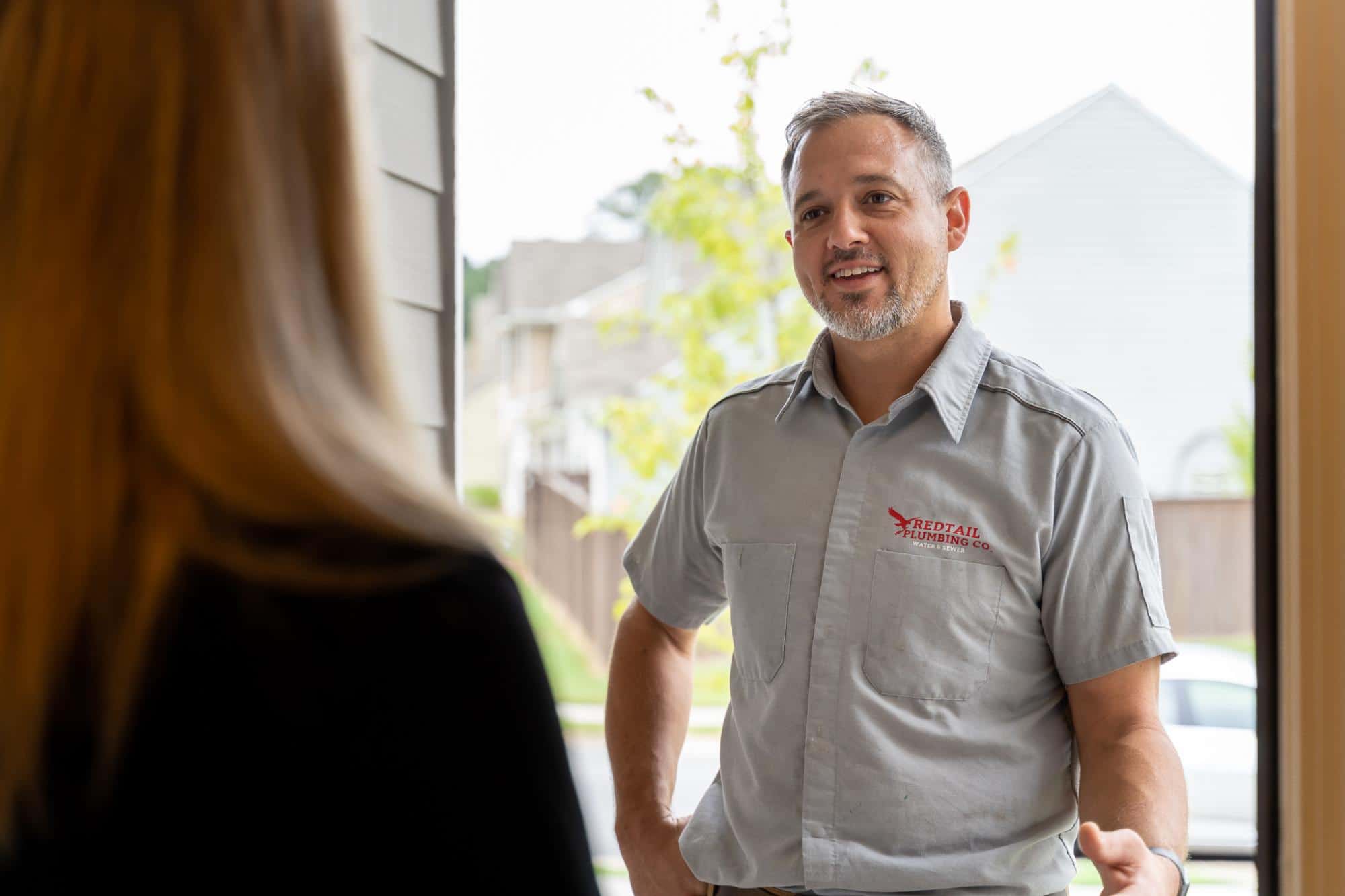 Redtail Plumbing arriving at a door for a job